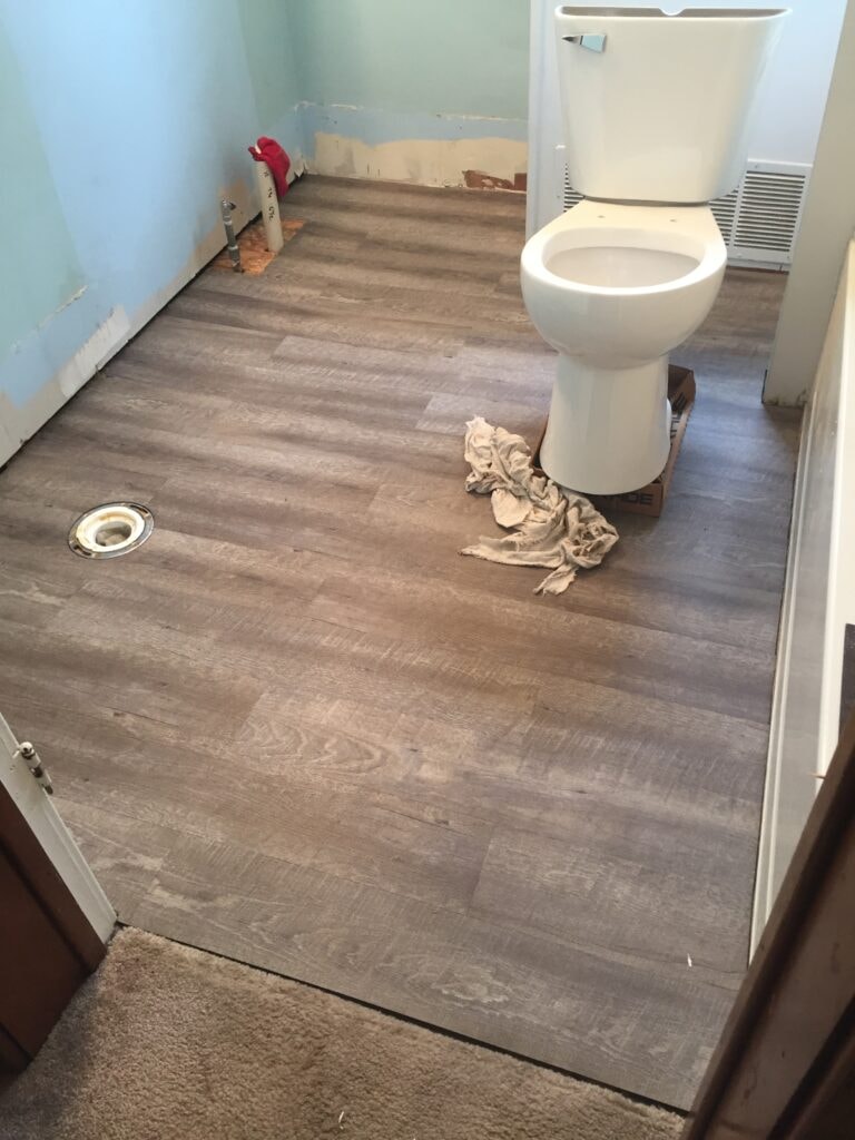 Bathroom remodel Findlay — during: new luxury vinyl plank flooring laid with toilet reinstalled, Findlay, Ohio