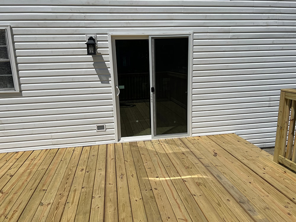 Deck addition — after: new sliding glass patio door installed on exterior wall, deck decking visible in foreground, Findlay, Ohio