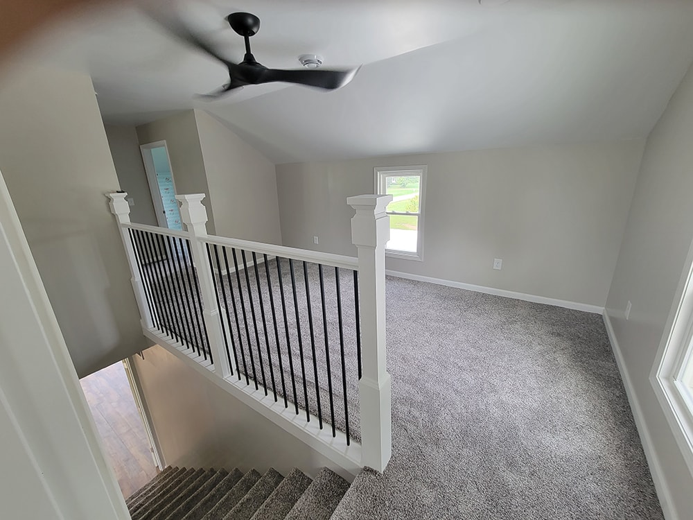 Entire house remodel — after: upstairs landing view showing staircase railing and loft area — Arlington, Ohio