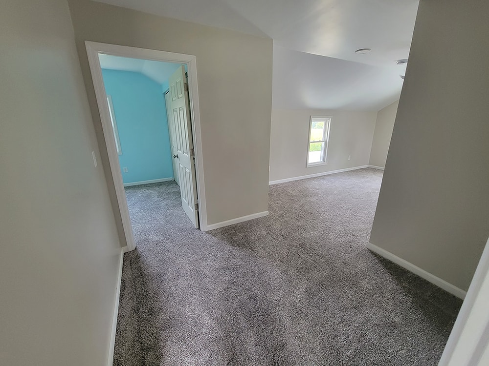 Entire house remodel — after: upstairs hallway view showing bedroom doorways and carpet — Arlington, Ohio