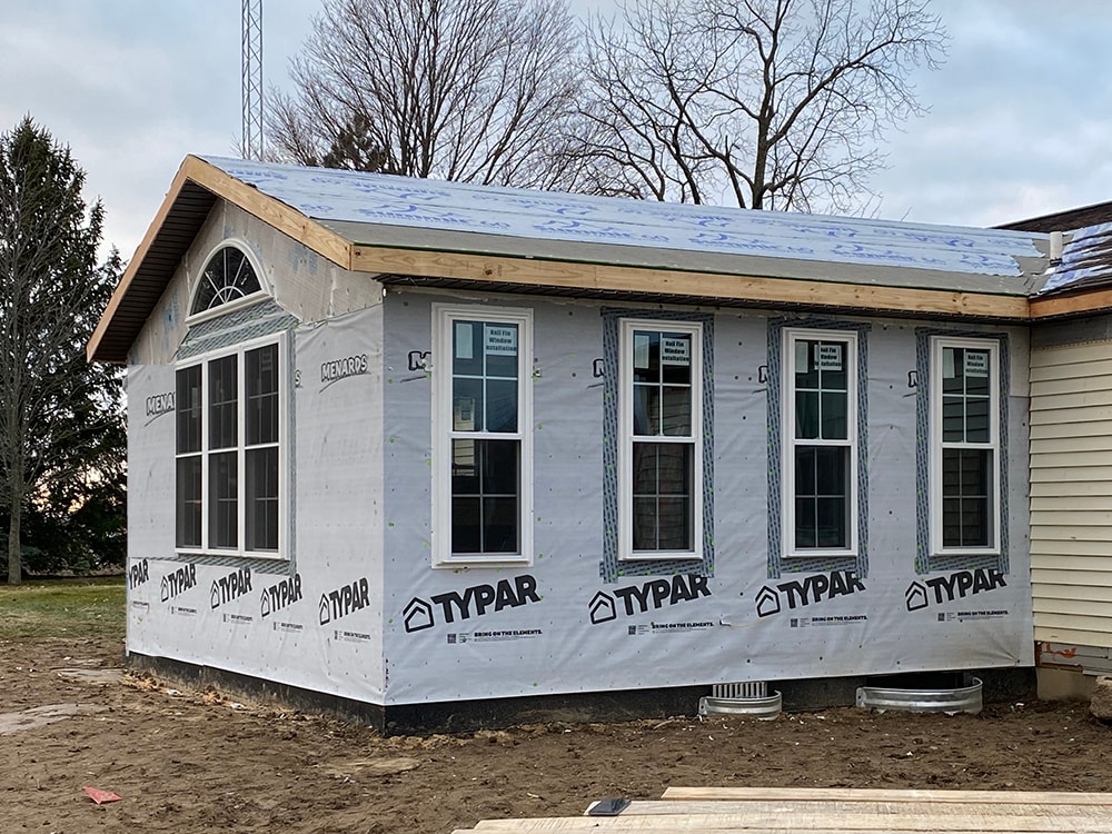 Room addition Fostoria — exterior wrapped in Typar house wrap with windows installed including arched transom window in gable, Fostoria, Ohio