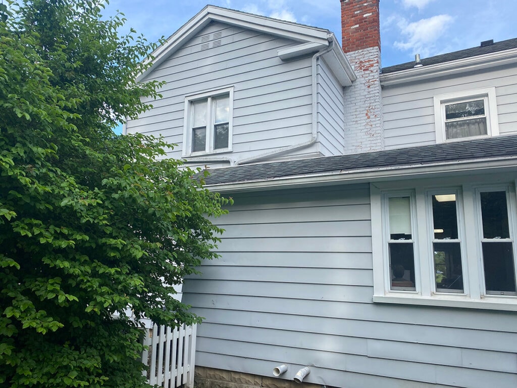 Hancock Park District siding — before: side view of Welcome Center with original light gray siding and brick chimney, Findlay, Ohio