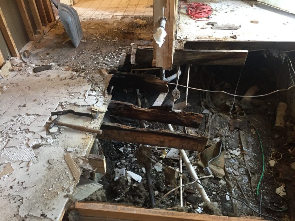 Kitchen family room remodel Arcadia — before: rotted subfloor and joists exposed during demolition, Arcadia, Ohio