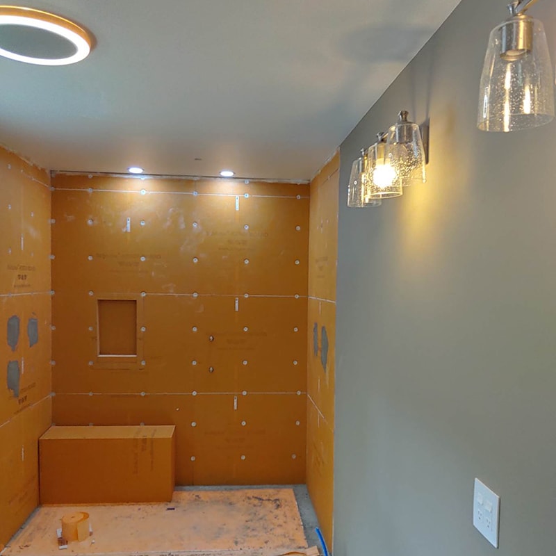 Large home addition — master bathroom shower with Wedi backer board installed, niche framed, and vanity lights hung, Findlay, Ohio