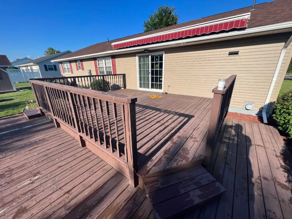 New composite deck — before, close view of worn deck boards and dark metal railing, Fostoria, Ohio