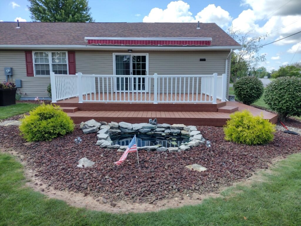 New composite deck — after, completed deck with white vinyl railing and pond feature in foreground, Fostoria, Ohio