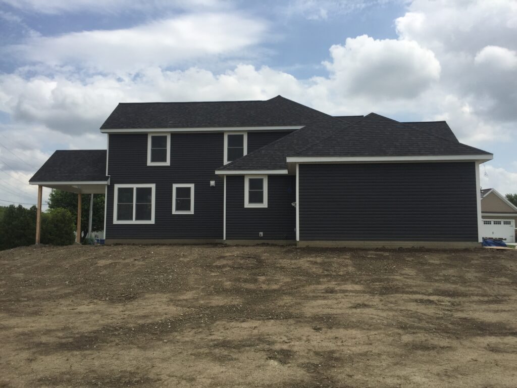 New construction composite siding Bowling Green — near complete: side view showing dark siding and attached garage, Bowling Green, Ohio