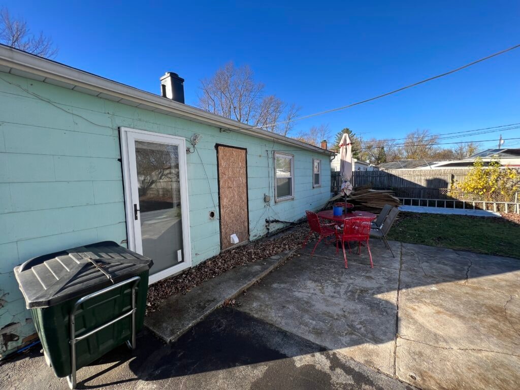 New vinyl siding — house rear before installation with original teal siding, Fostoria, Ohio