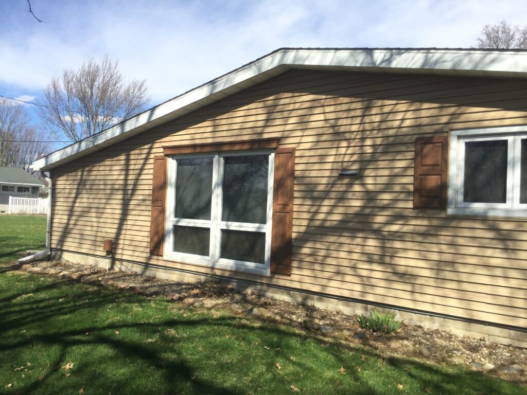 Roof replacement Fostoria — side of home with new fascia, soffit, and wrapped windows, Fostoria, Ohio