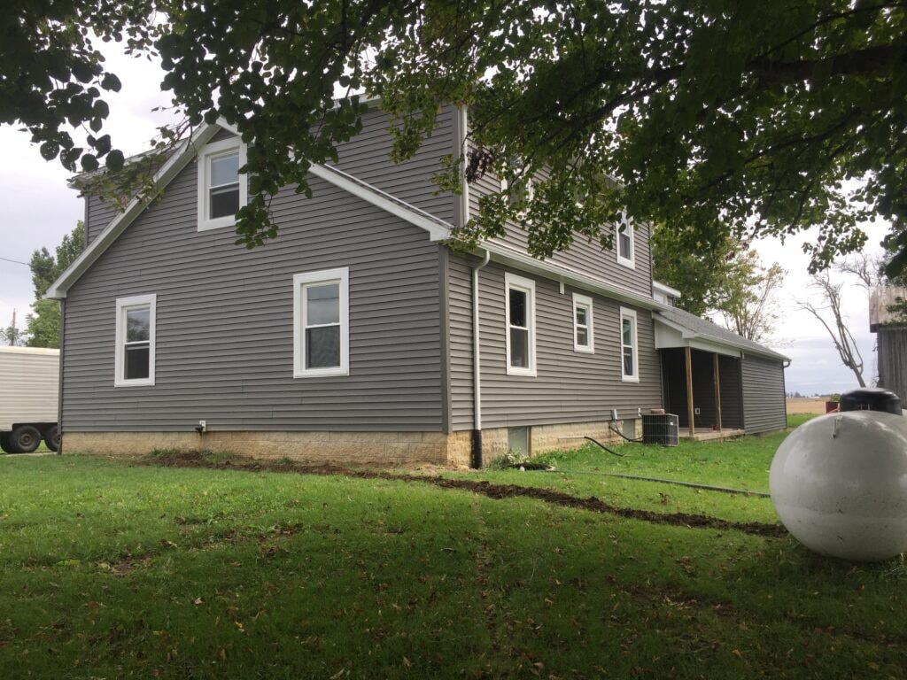 Siding and new windows Findlay — after: side view of completed two-story home with new gray siding and multiple replacement windows, Findlay, Ohio