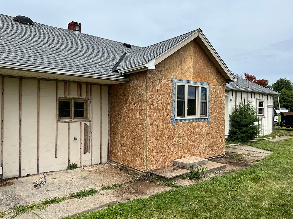 Small room reframe — exterior after, reframed addition with OSB sheathing and new windows installed, side view, Findlay, Ohio