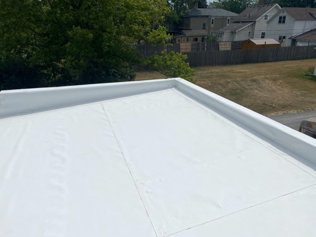 TPO roof replacement Findlay — after: completed TPO membrane close-up showing clean seam lines and fully wrapped white parapet cap, Findlay, Ohio