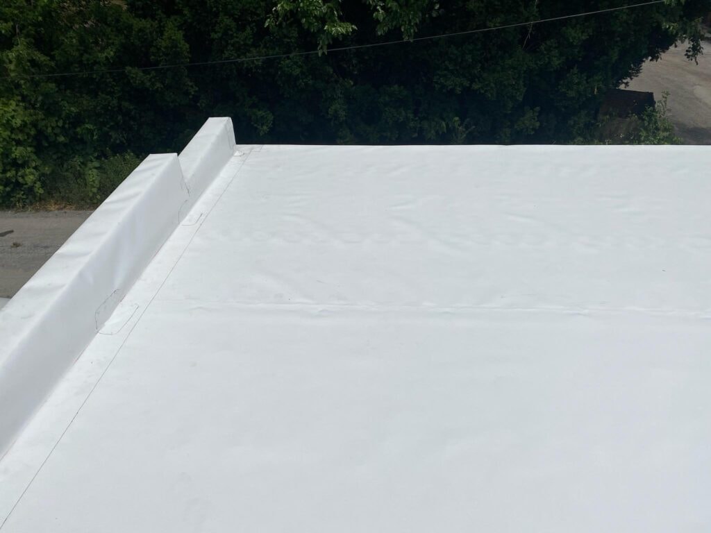 TPO roof replacement Findlay — after: completed TPO membrane corner detail showing crisp parapet wrap, seam lines, and clean white membrane surface, Findlay, Ohio