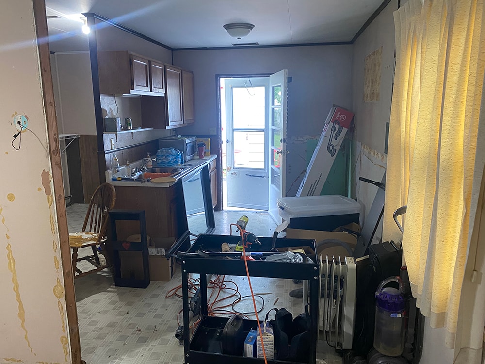 Whole house remodel before — kitchen with dark cabinets, old appliances, and cluttered work-in-progress state, Fostoria, Ohio